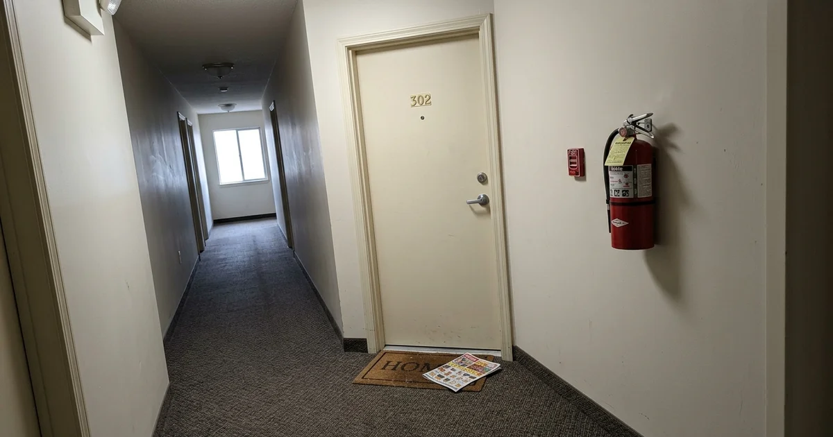 A closed apartment door in a quiet corridor